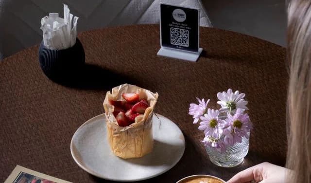 Código QR mal ubicado en una esquina poco visible de la mesa
